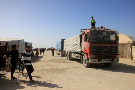 Des Palestiniens observent l'arrivée de camions transportant de l'aide humanitaire à Khan Younès, dans le sud de la bande de Gaza, le 1er février 2026