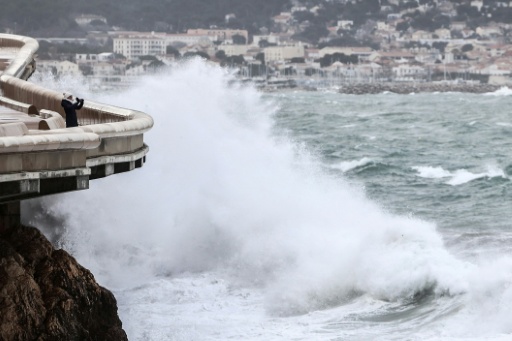 Une personne prend une photo depuis la Corniche tandis que les vagues s’écrasent contre le littoral à Marseille, le 12 février 2026