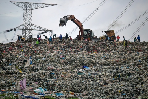 Des engins de chantier nivellent un énorme tas de déchets à la décharge de Cipayung à Depok, le 15 janvier 2026 en Indonésie