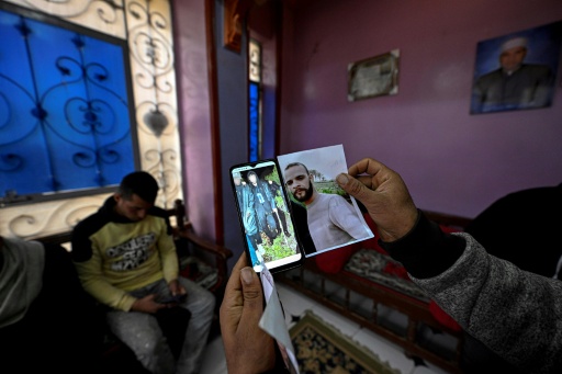 Un proche montre un portrait de Mohamed Abdelsamad, 32 ans, et une photo de lui sur un téléphone - prise avant qu'il ne soit porté disparu en Méditerranée - lors d'un entretien avec l'AFP dans le village égyptien d'Abdallah Aziza le 21 janvier 2026