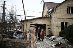 Un pompier ukrainien passe devant une maison détruite par une attaque aérienne à Sofiivska Borshchagivka, dans la région de Kiev, le 22 février 2026
