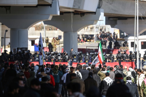 Des membres des forces de sécurité irakiennes font face à des manifestants pro-Iran près de la Zone verte, où se trouve l’ambassade des États-Unis, à Bagdad, le 1er mars 2026.