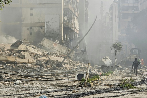 Des secouristes sur le site d'une frappe aérienne israélienne qui a ciblé le quartier de Haret Hreik, dans la banlieue sud de Beyrouth, le 4 mars 2026 au Liban