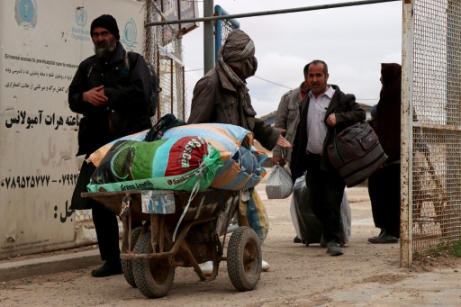 Des ressortissants afghans arrivent avec leurs effets personnels au poste-frontière d’Islam Qala, entre l’Afghanistan et l’Iran, dans la province de Herat Province, le 10 mars 2026, après leur arrivée en provenance d’Iran dans le contexte de la guerre au Moyen-Orient.