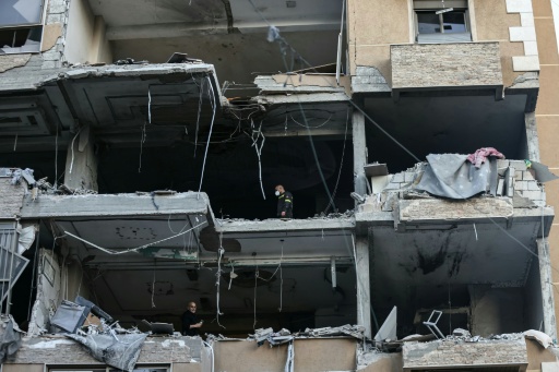 Des secouristes dans un immeuble détruit par une frappe aérienne israélienne dans le quartier de Aïcha Bakkar à Beyrouth, le 11 mars 2026 au Liban