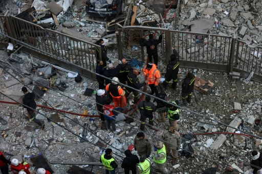 Des secouristes et des habitants sur le site d'une frappe aérienne israélienne dans le quartier d'Aïcha Bakkar à Beyrouth, le 11 mars 2026 au Liban