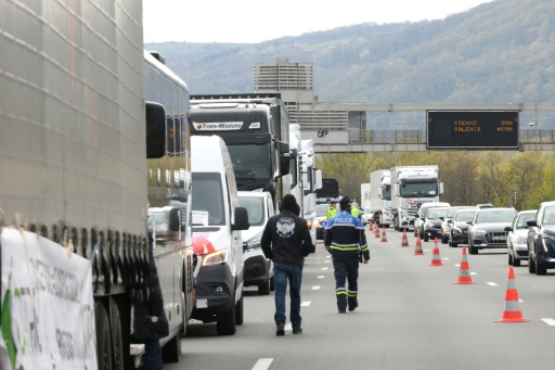 Un policier sur le site d'une manifestation de chauffeurs routiers bloquant l'autoroute A7, au sud de Lyon, pour protester contre la hausse des prix du carburant, à Chasse-sur-Rhône, le 28 mars 2026 en Isère