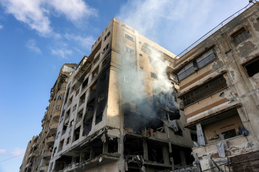 De la fumee s'echappe d'un immeuble residentiel touche par une frappe israelienne dans le quartier d'Al-Ramal a Gaza