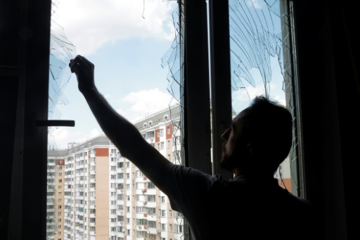 Un habitant retire des eclats de verre d'une fenetre brisee a Krasnogorsk, region de Moscou