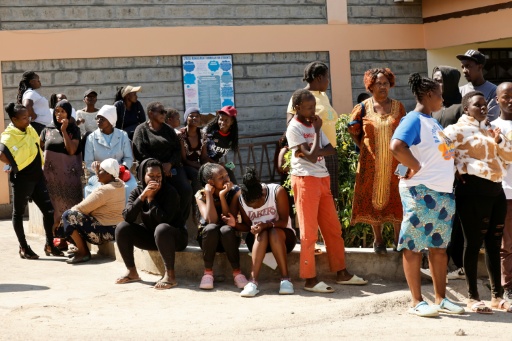 Des proches attendent le 28 mai 2026 dans la cour des nouvelles de pensionnaires de l'école de filles de Gilgil, au Kenya, dont un dortoir a été ravagé dans la nuit par un incendie qui a tué 16 élèves et en a blessé 79