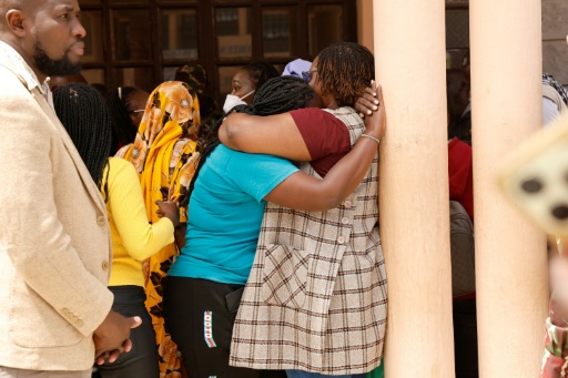 Deux proches d'élèves se réconfortent le 28 mai 2026 dans la cour de l'école de filles de Gilgil, au Kenya, où un dortoir a été ravagé durant la nuit par un incendie meurtrier