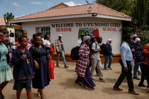 Des proches attendent le 28 mai 2026 devant l'école pour filles Utumishi, dont un dortoir a été ravagé durant la nuit par un incendie meurtrier
