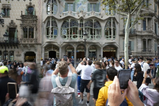 Des touristes devant la façade colorée de la Casa Batlló, œuvre d'Antoni Gaudí à Barcelone