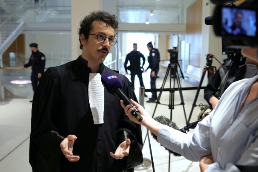 Un avocat en robe noire dans la salle des pas perdus du palais de justice de Paris