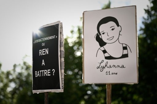 Pancartes lors d'une manifestation devant un palais de justice : un portrait dessiné de Lyhanna et une pancarte critiquant les dysfonctionnements