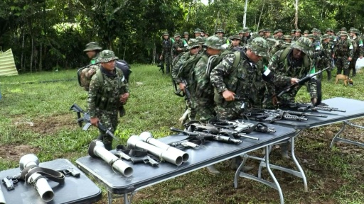Une colonne de guérilleros de la CNEB dépose ses armes sur des tables lors de la cérémonie de désarmement dans le Putumayo, en Colombie