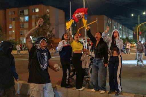 Des manifestants brandissent des drapeaux lors d'affrontements avec la police à Bogota