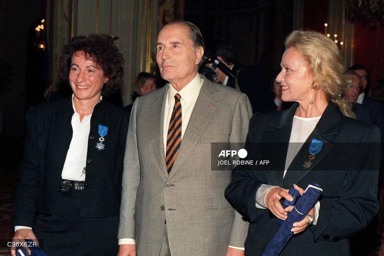 François Mitterrand entouré de deux femmes décorées, dans un salon de l'Élysée