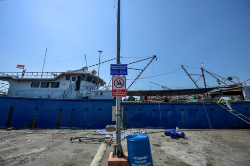 Des membres d'équipage sur un bateau de pêche au port de Nusantara en Indonésie