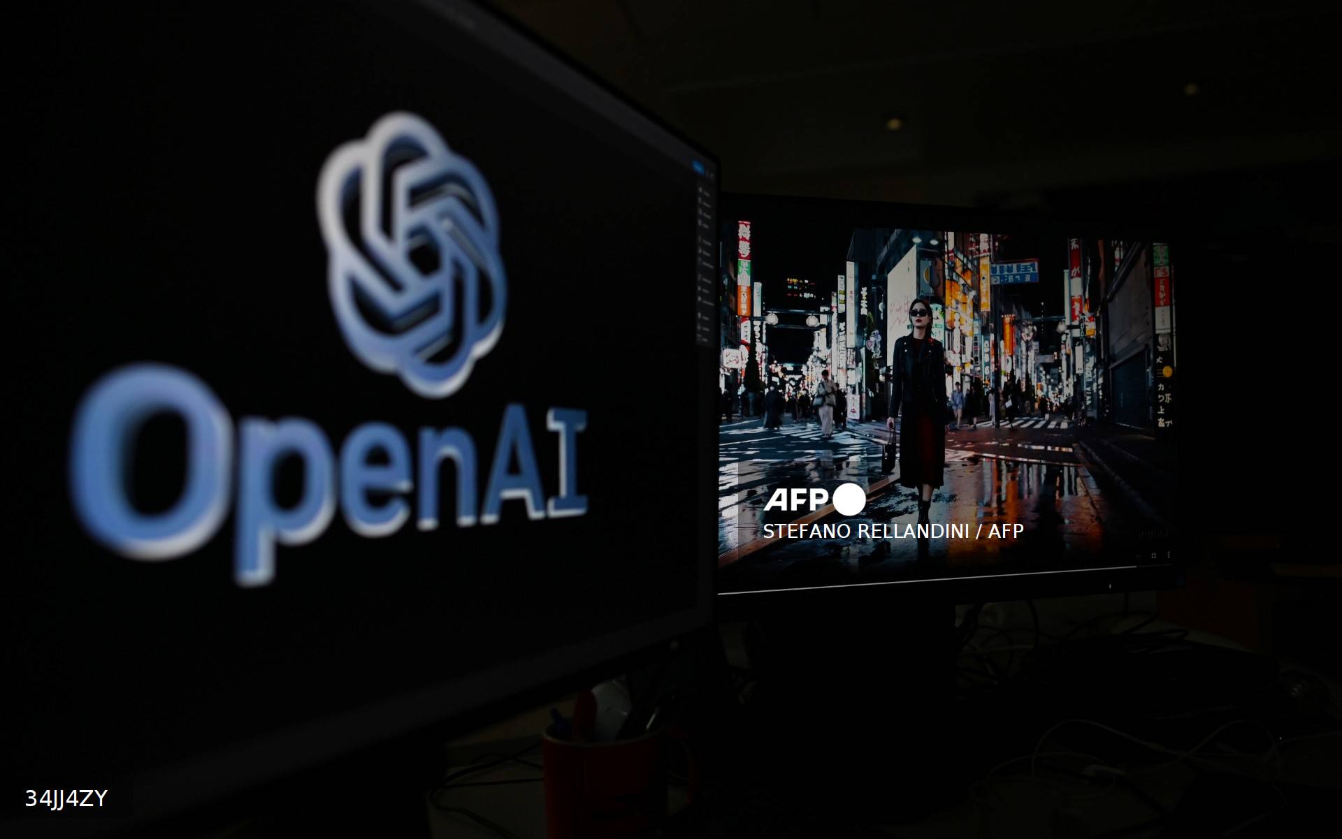 Le logo d'OpenAI et une vidéo générée par son outil Sora affichés sur des écrans d'ordinateur