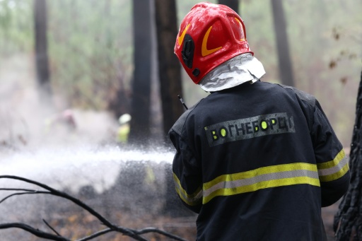 Un pompier en tenue d'intervention lutte contre un feu de végétation dans le sud-ouest de la France