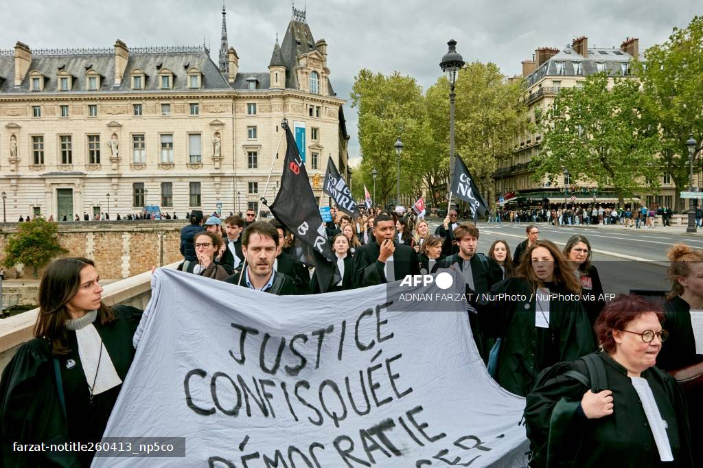 Avocats en robe portant une banderole Justice confisquée sur un pont de Paris lors de la manifestation contre la loi Darmanin, 13 avril 2026
